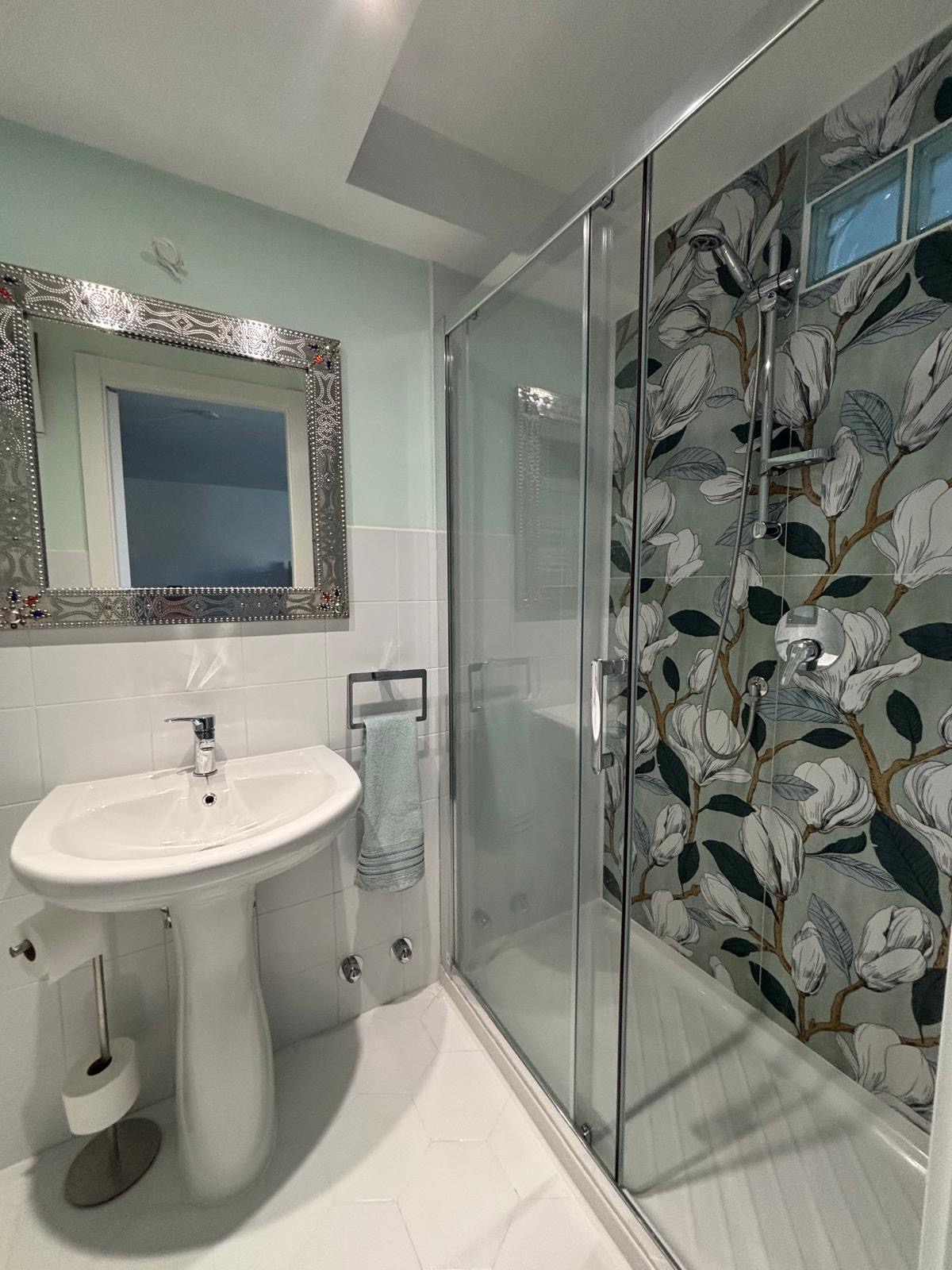 Doccia con parete decorata a magnolie nel bagno privato di The Green Space