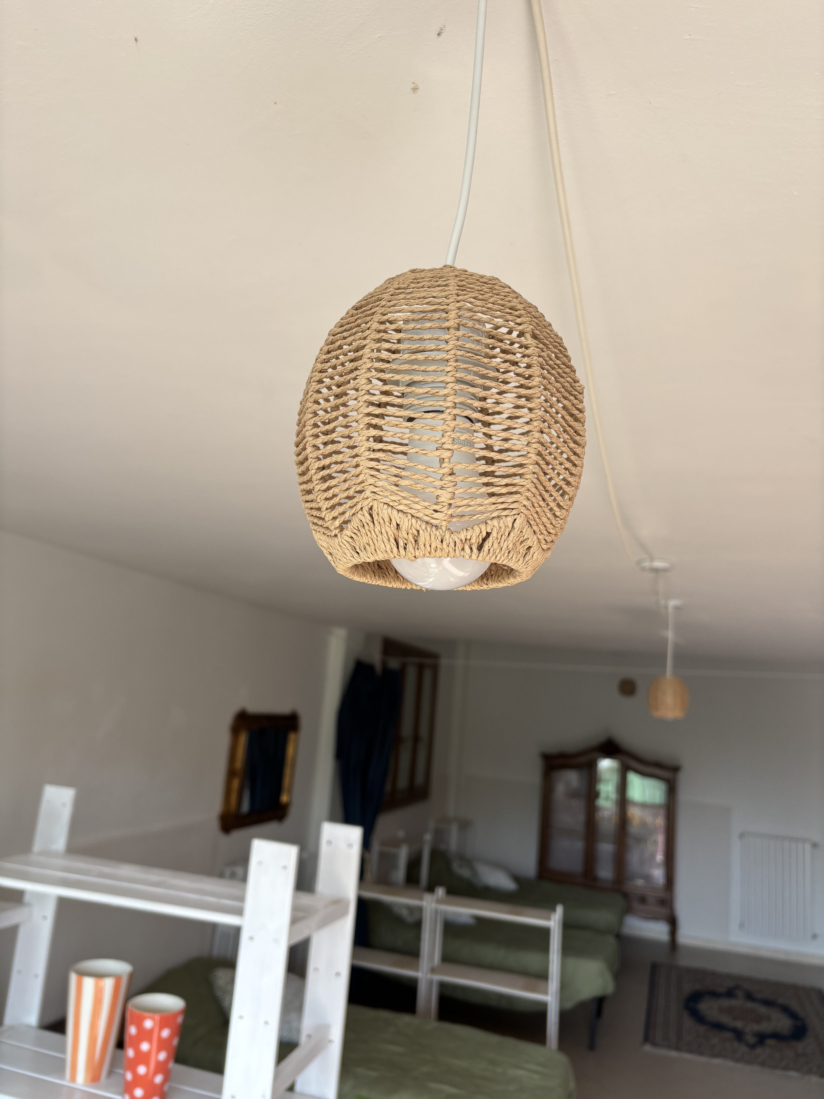 Lampada in rattan sospesa sopra la zona pranzo di The Green Space