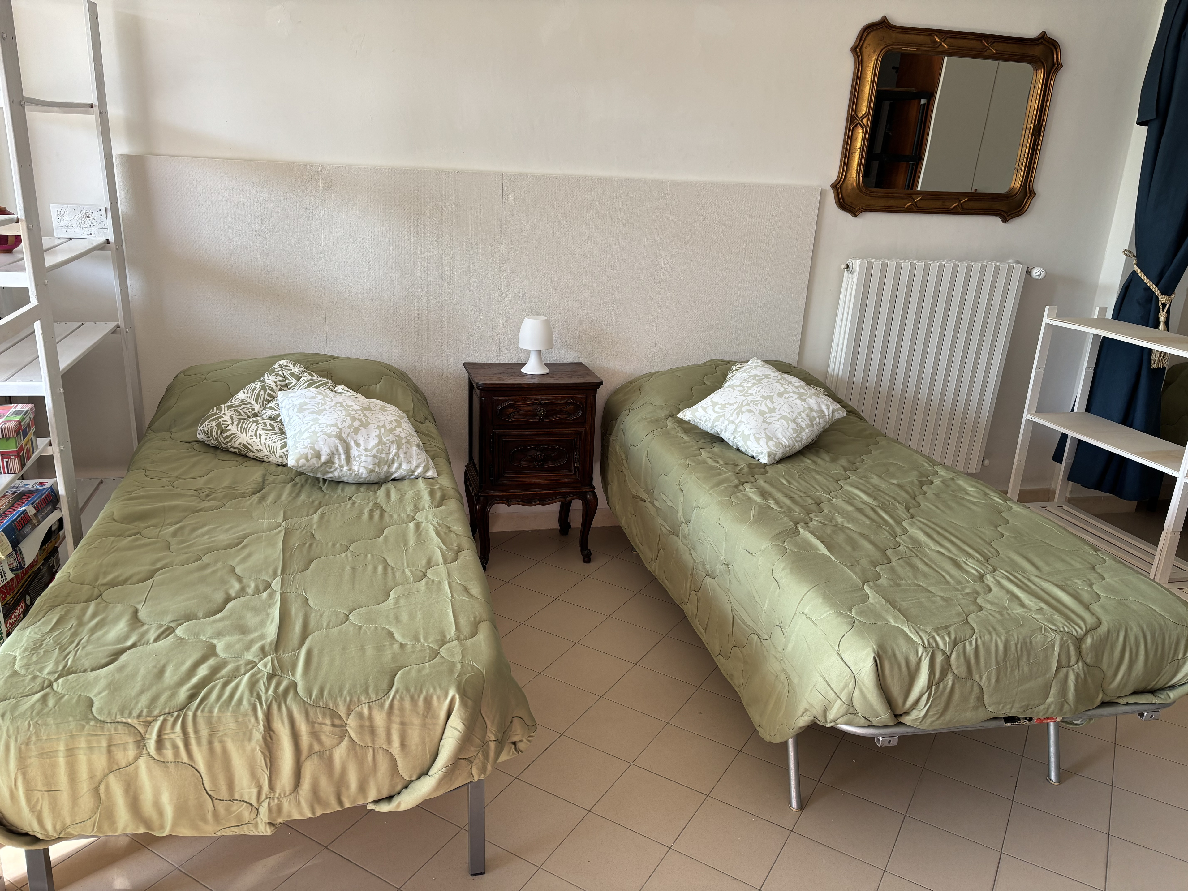 Letti singoli con comodino d'epoca e specchio dorato a The Green Space